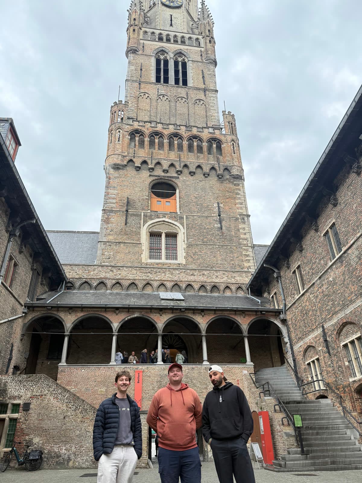 Three of us standing in the courtyard of the Halle, the belfry tower rising behind