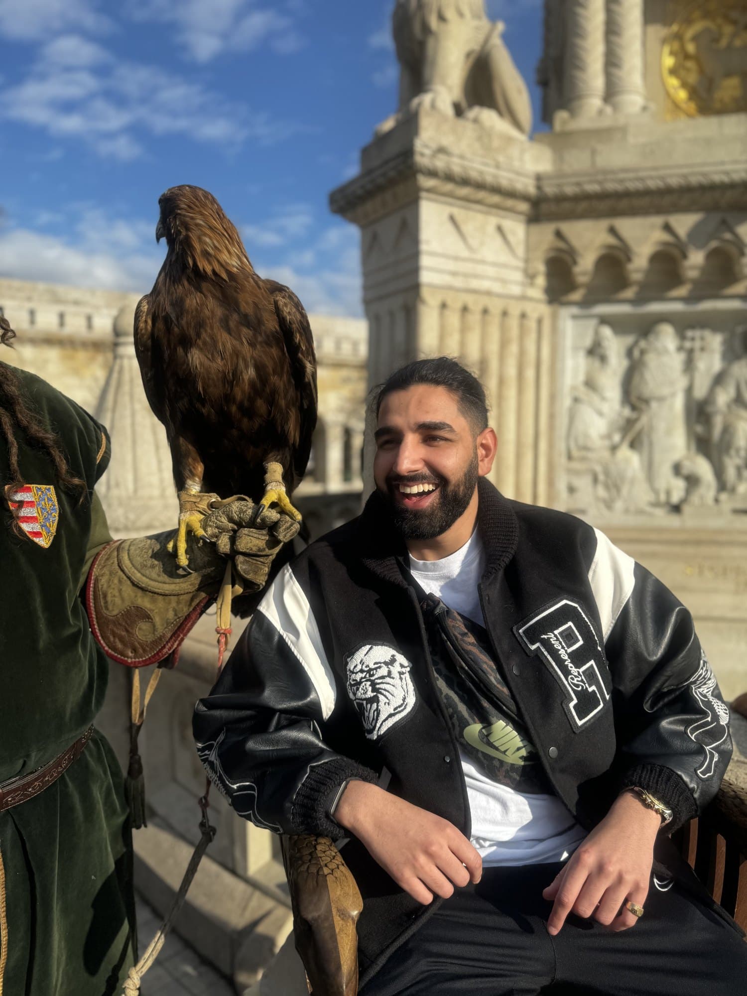 Param laughing beside an eagle perched on a falconer’s gloved hand at Fisherman’s Bastion