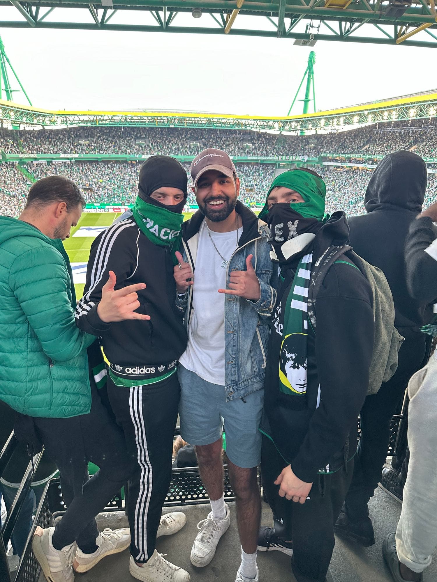 Param in the home end of a football stadium among masked supporters in green scarves