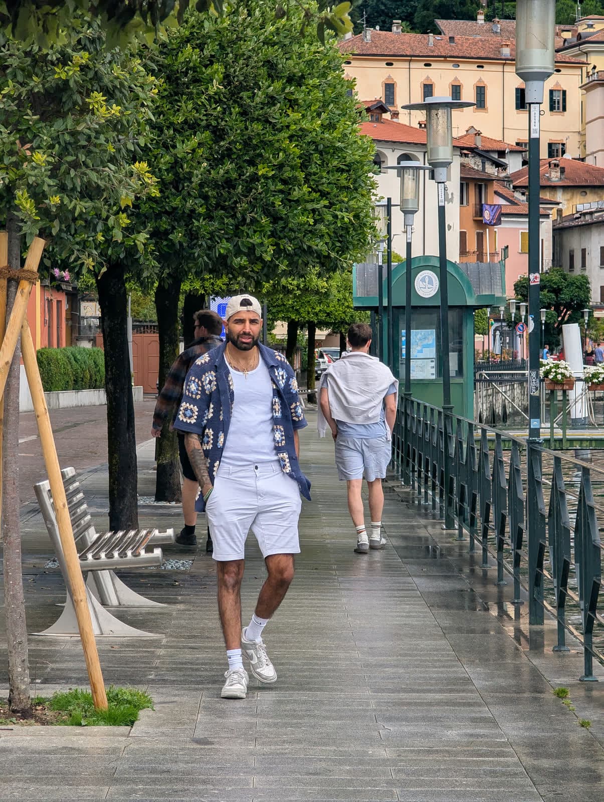 Me walking along the promenade, a friend behind and the town rising up the hill