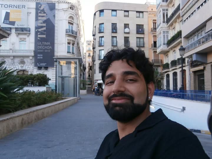 Me in a black shirt in a Valencia street, a large Tàpies exhibition banner on the building behind