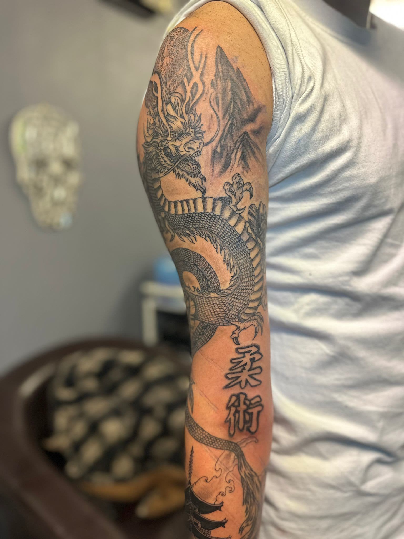 Full arm — dragon, mountains, and kanji visible